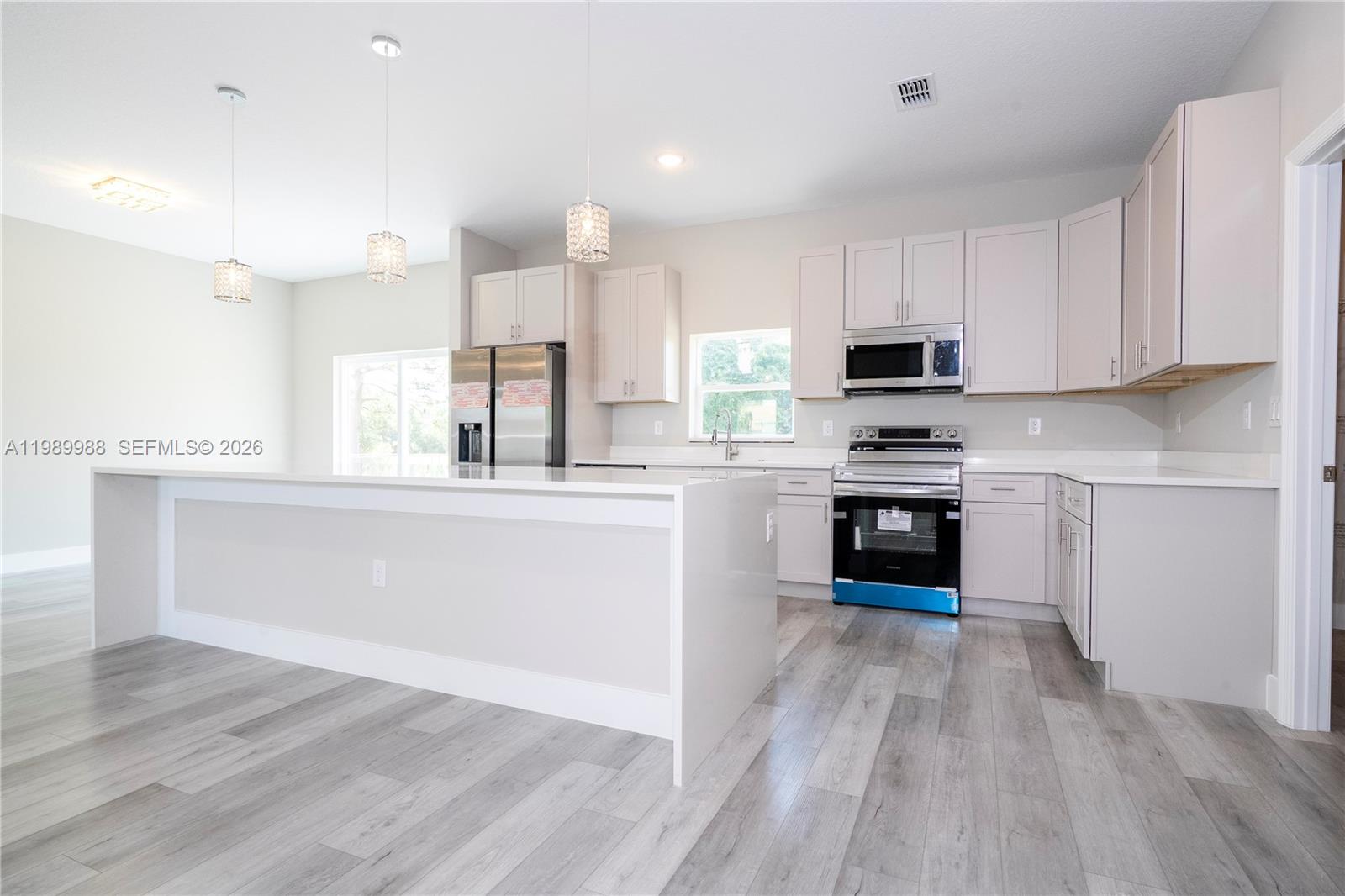 7916 Granada Road Sebring, FL 33876 - Photo 19 of 60 a kitchen with stainless steel appliances kitchen island granite countertop a stove a sink and white cabinets