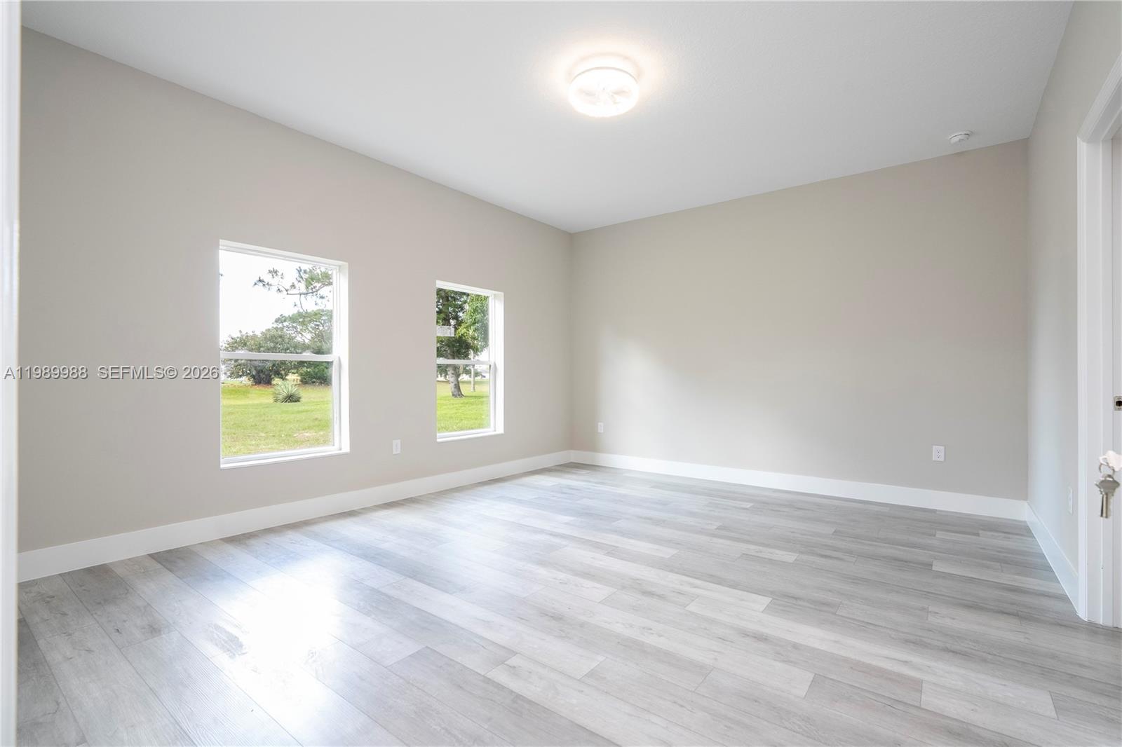 7916 Granada Road Sebring, FL 33876 - Photo 30 of 60 an empty room with wooden floor and windows