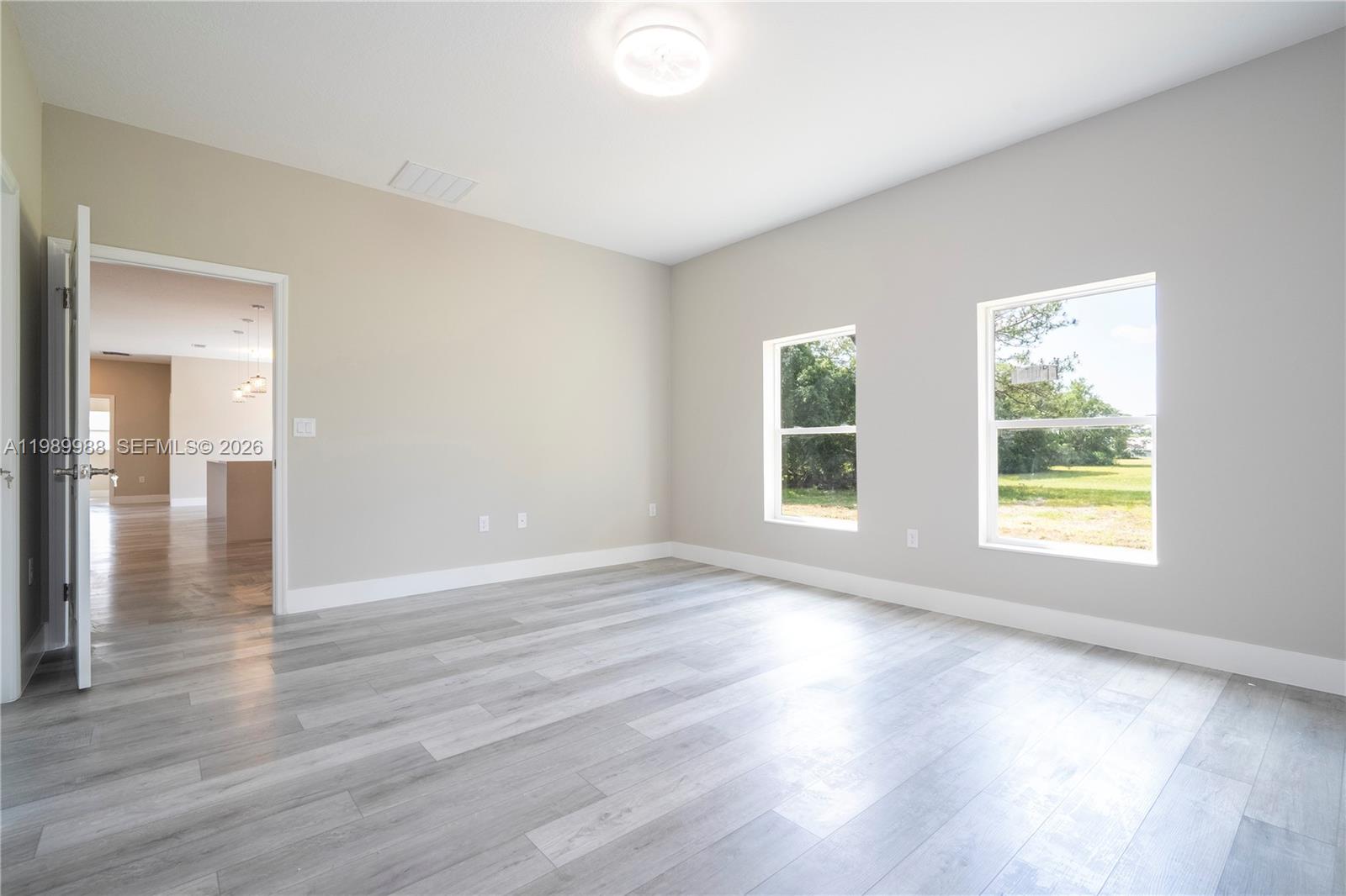 7916 Granada Road Sebring, FL 33876 - Photo 35 of 60 an empty room with wooden floor and windows