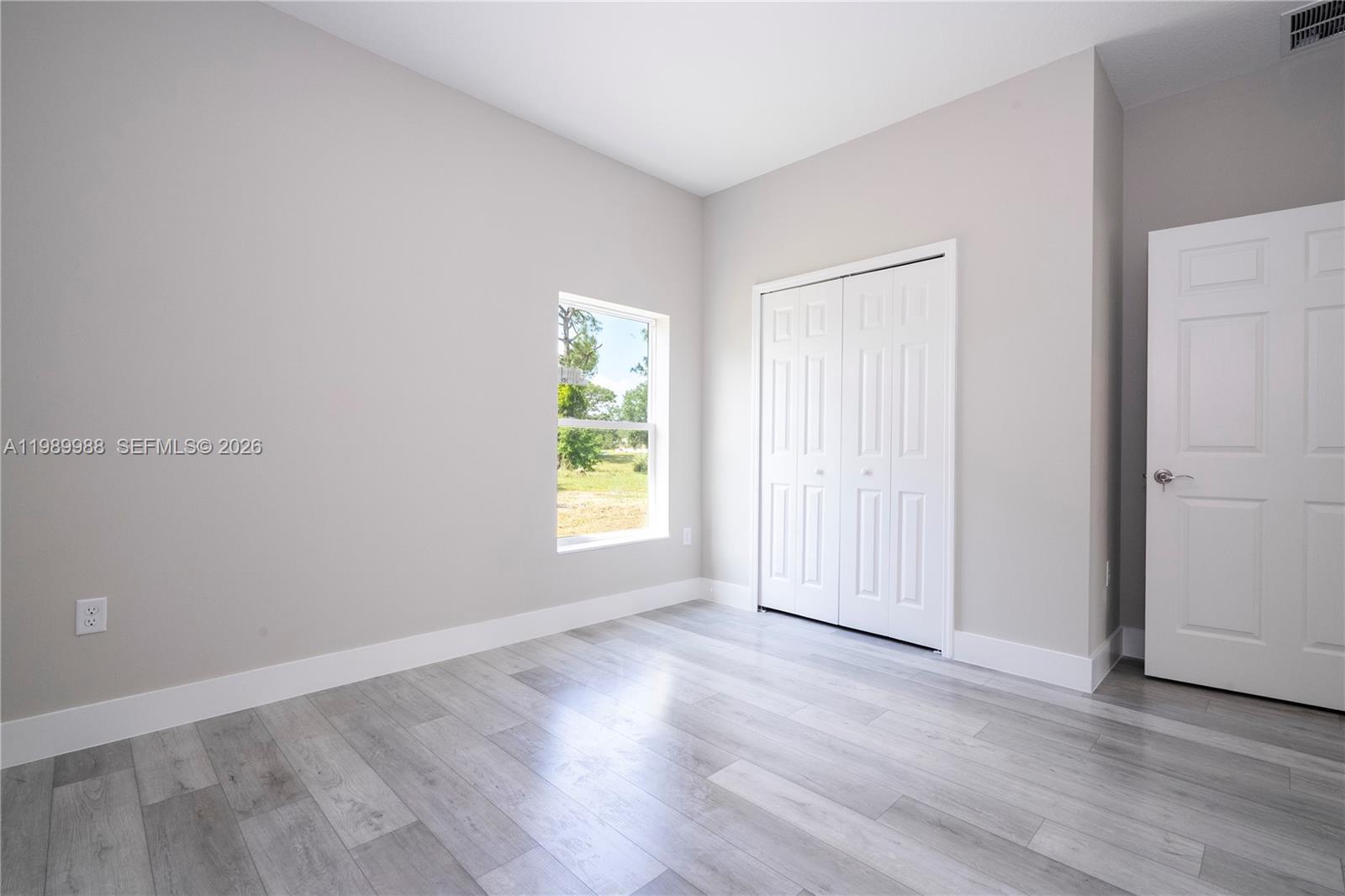 7916 Granada Road Sebring, FL 33876 - Photo 43 of 60 an empty room with wooden floor and windows