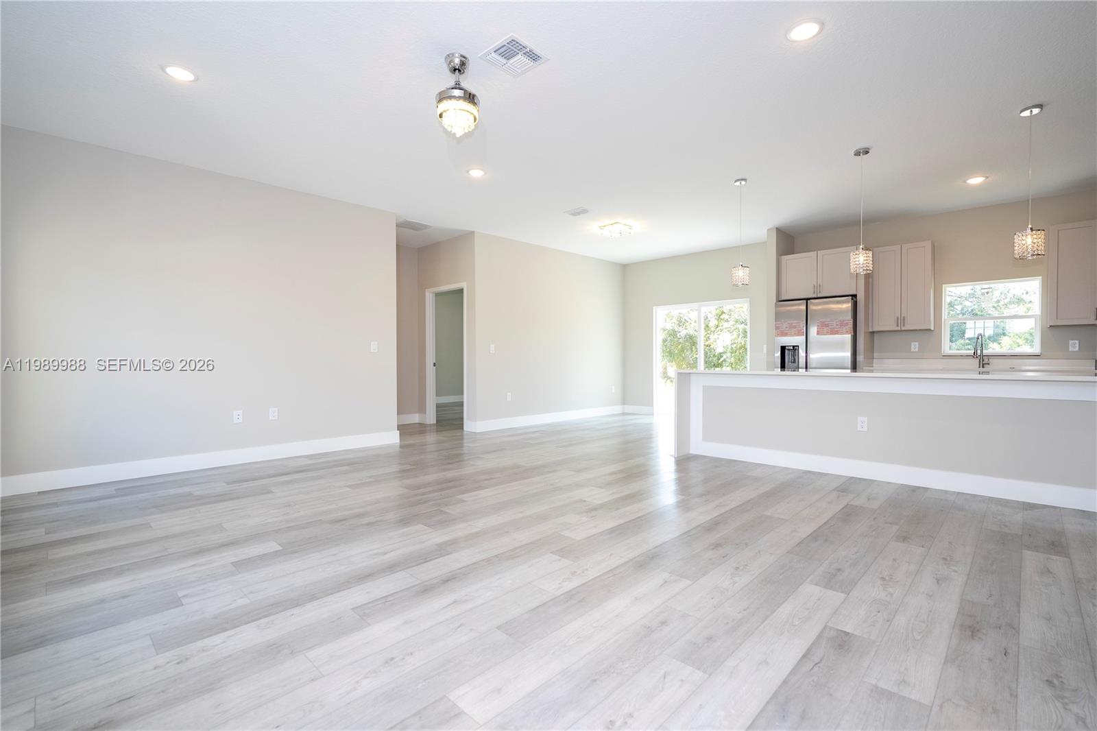 7916 Granada Road Sebring, FL 33876 - Photo 9 of 60 an empty room with wooden floor and windows
