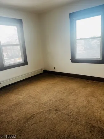 an empty room with a window and cabinet