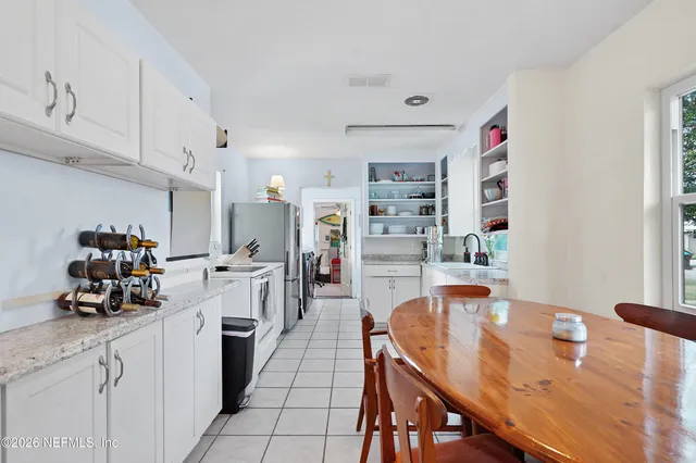 a kitchen with stainless steel appliances kitchen island granite countertop a sink a stove and cabinets