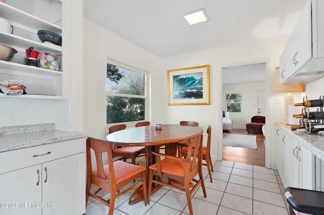 a view of a dining room with furniture and many windows