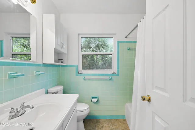 a bathroom with a sink a toilet and a window