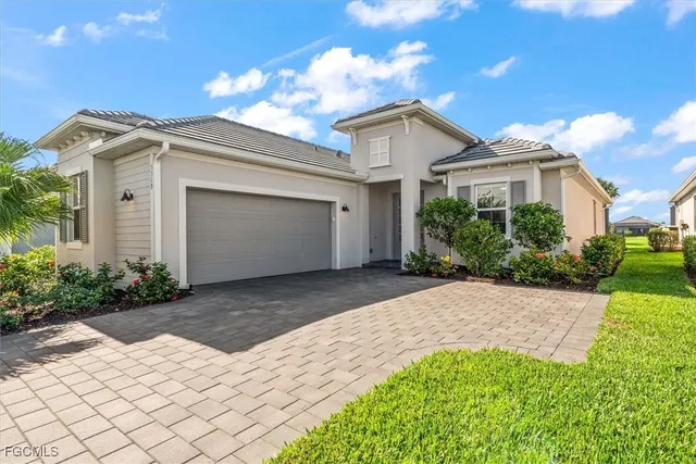 a view of a white house with a yard and plants