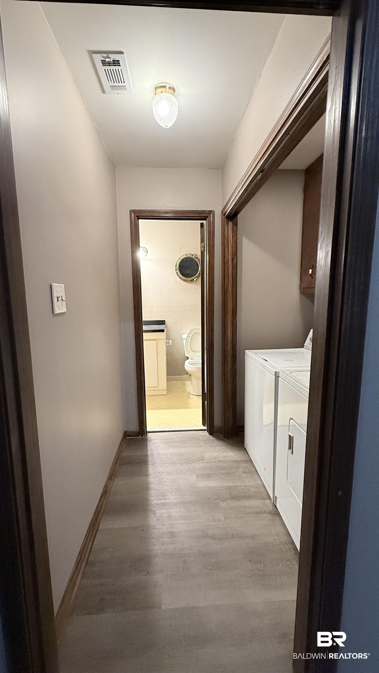 4131 Springdale Road Mobile, AL 36609 - Photo 13 of 28 Laundry room featuring light wood-type flooring, cabinet space, and washer and dryer