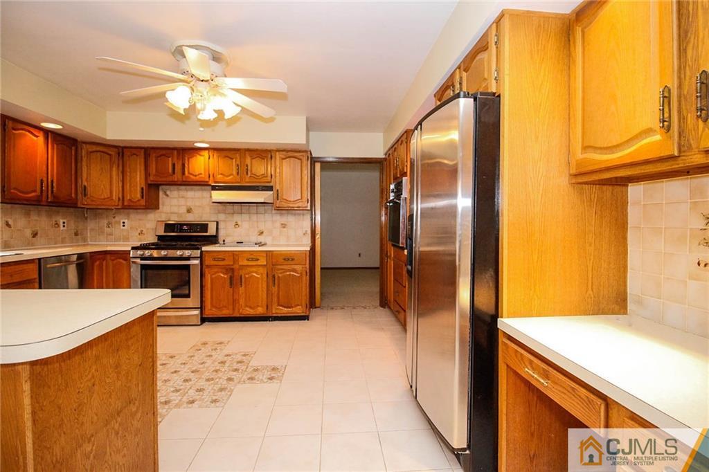 53 Hillsdale Road Edison, NJ 08820 - Photo 9 of 25 a kitchen with stainless steel appliances granite countertop a refrigerator a stove and a sink with cabinets