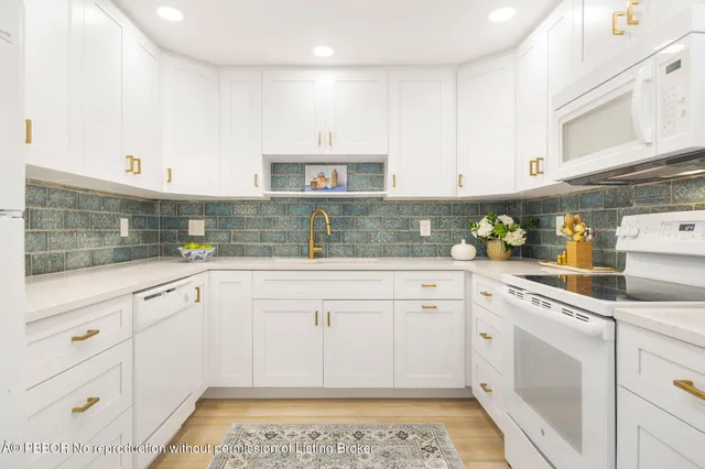 a kitchen with granite countertop white cabinets and white appliances