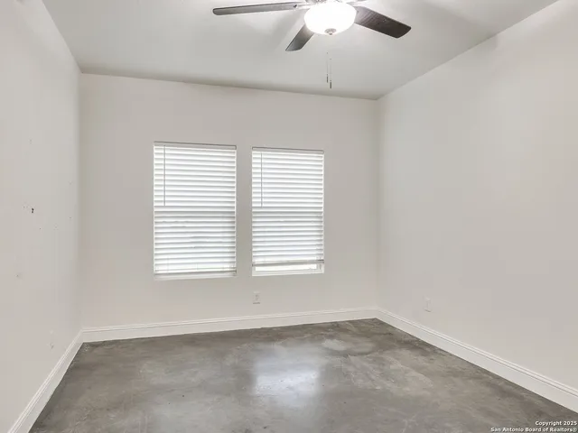 an empty room with closet and a ceiling fan