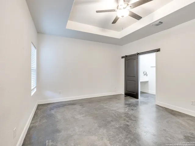an empty room with closet and windows