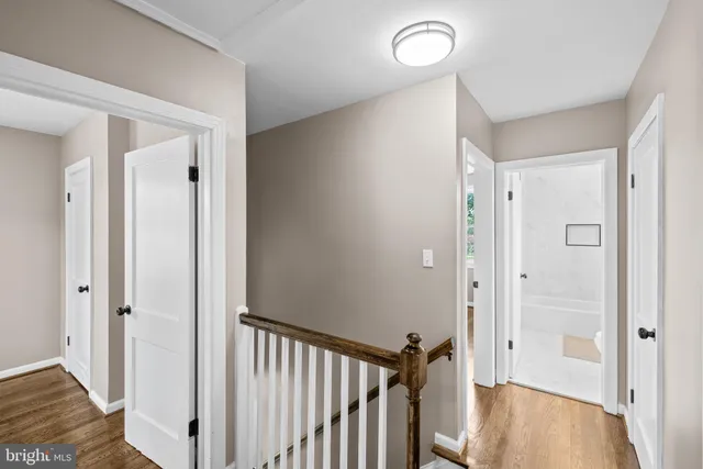 a view of a hallway with wooden floor and staircase