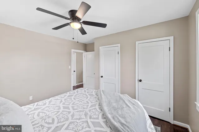 a bedroom with a bed and a ceiling fan