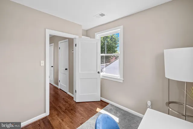 a view of a livingroom with wooden floor and a bathroom