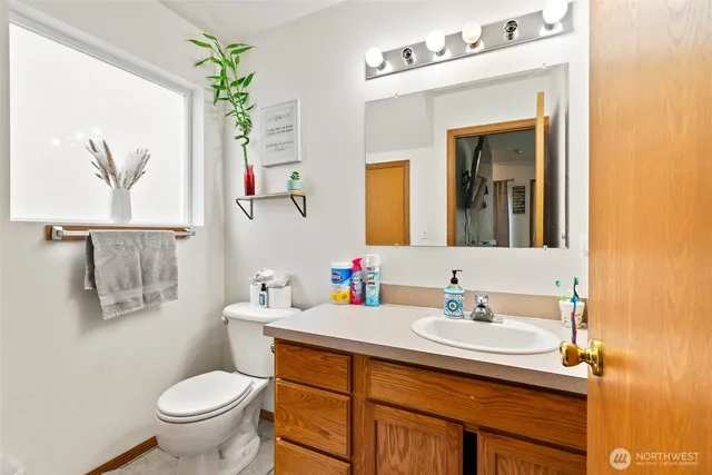 a bathroom with a sink vanity mirror and toilet