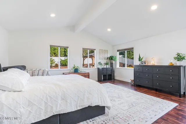 a spacious bedroom with a large bed and a dresser