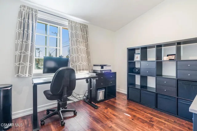 a view of a workspace with furniture and a window