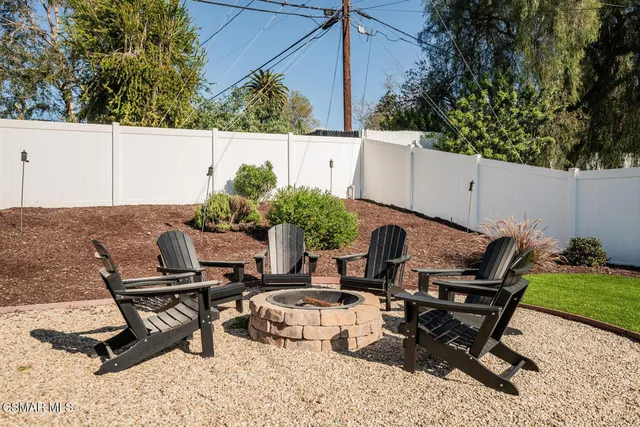 a view of a backyard with chair and potted plants
