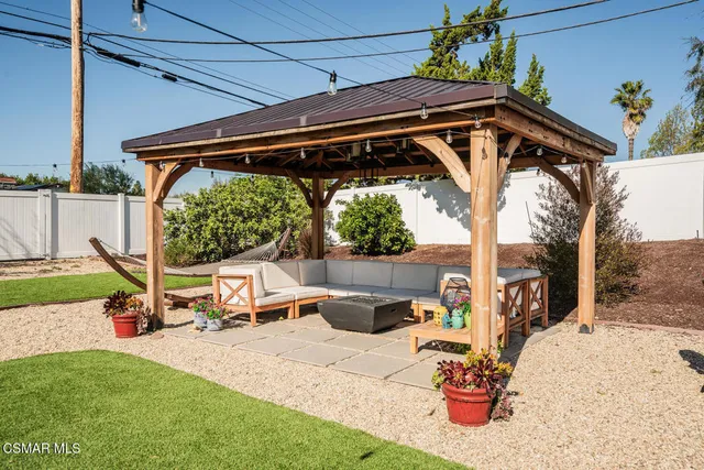 a view of backyard with a table and chairs under an umbrella