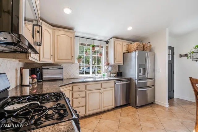 a kitchen with stainless steel appliances a stove a sink and a refrigerator
