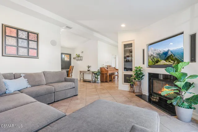 a living room with furniture a large window and a flat screen tv