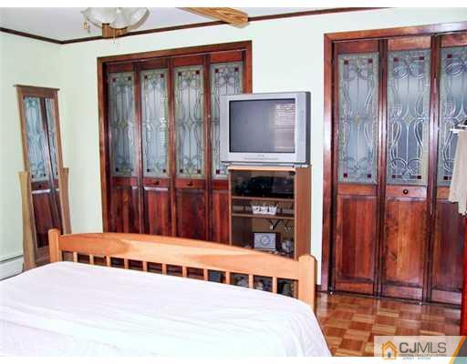 179 South Hill Road Colonia, NJ 07067 - Photo 5 of 19 a living room with a balcony a bed and a flat tv screen