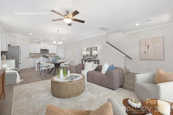 a living room with furniture and a view of kitchen