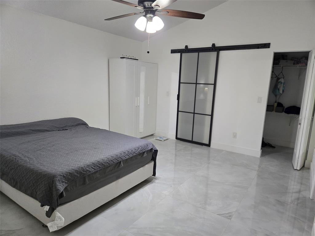 2280 Springwood Circle West Clearwater, FL 33763 - Photo 11 of 25 a spacious bedroom with a bed and a chandelier