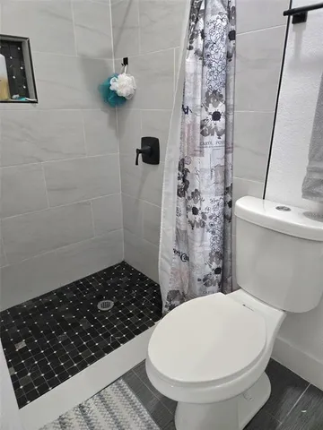 a bathroom with a toilet and a shower