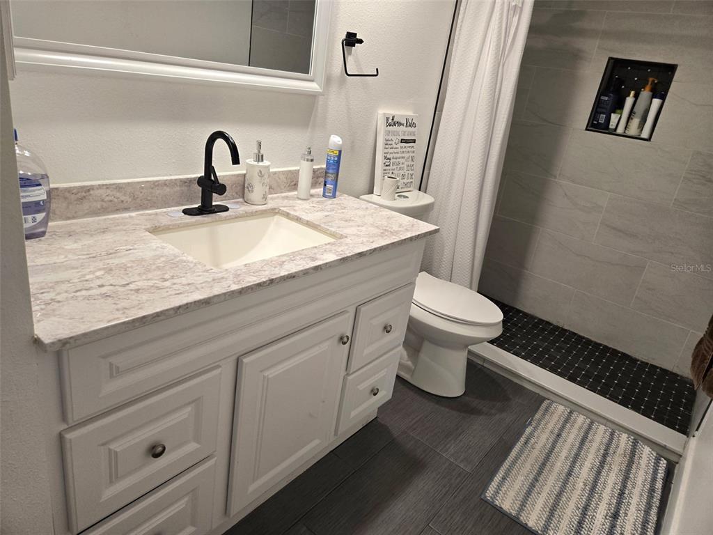 2280 Springwood Circle West Clearwater, FL 33763 - Photo 20 of 25 a bathroom with a granite countertop toilet sink and mirror