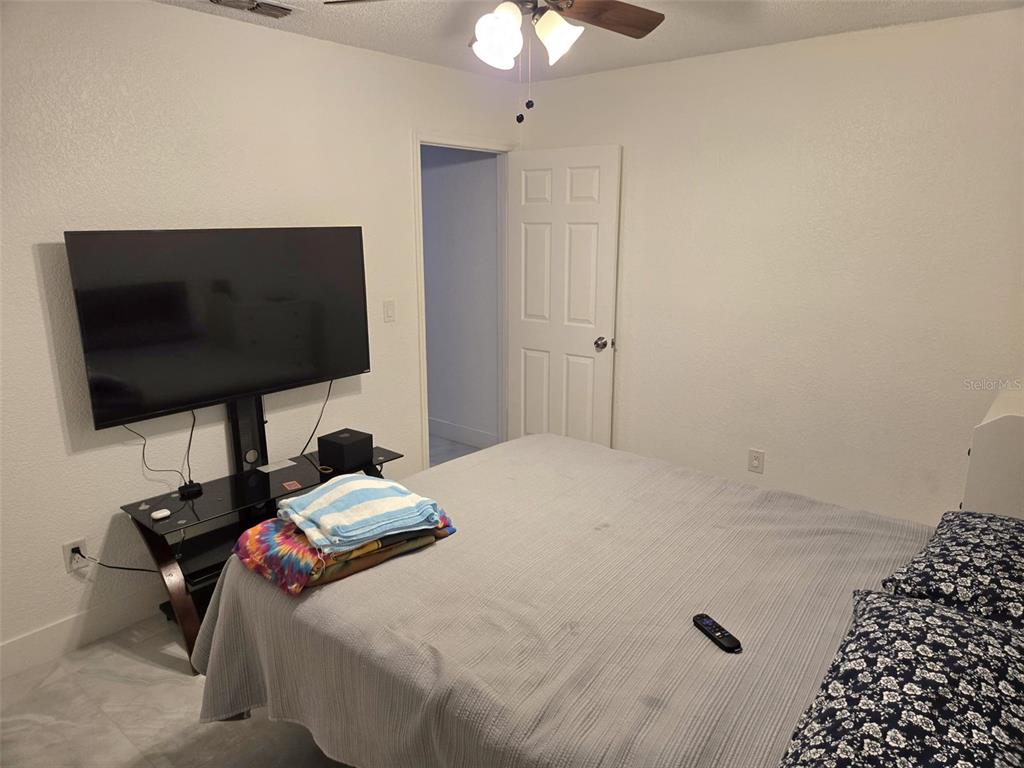2280 Springwood Circle West Clearwater, FL 33763 - Photo 23 of 25 a bedroom with a bed and a flat screen tv