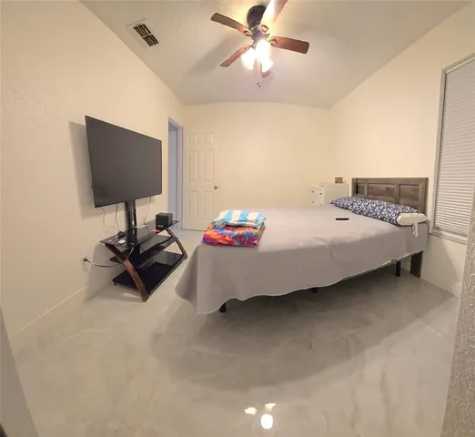a bedroom with a bed and a flat screen tv