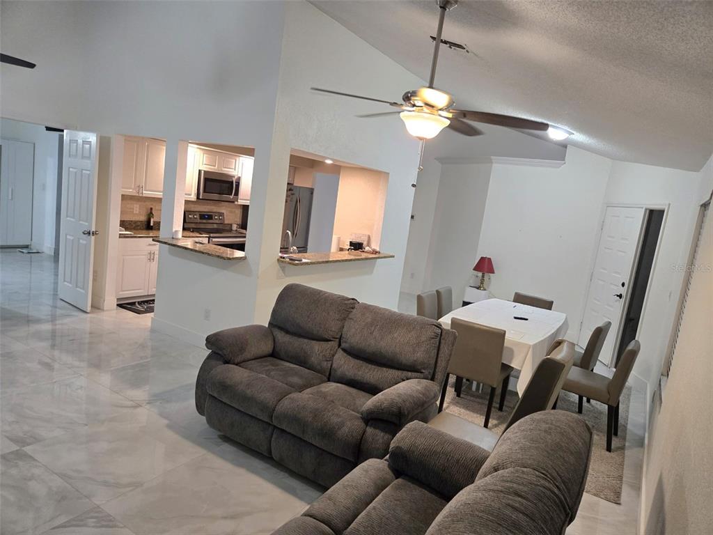 2280 Springwood Circle West Clearwater, FL 33763 - Photo 6 of 25 a living room with furniture a couch and a chandelier
