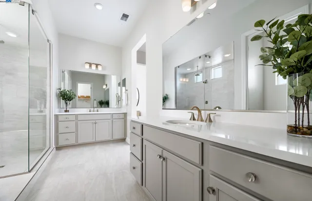 a large white kitchen with a sink and a mirror