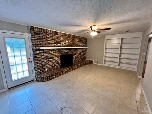 a view of an empty room and chandelier fan