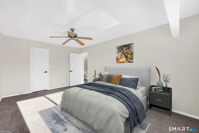 a bed room with a bed and a ceiling fan