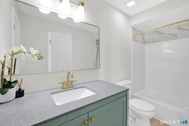 a bathroom with a sink a toilet and a mirror