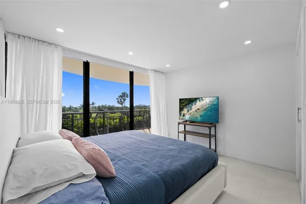 a bed sitting in a spacious bedroom next to a window