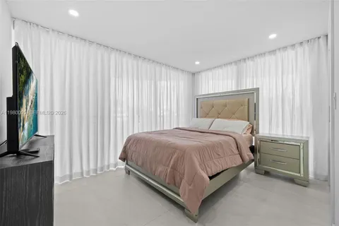 a bed sitting in a spacious bedroom next to a window