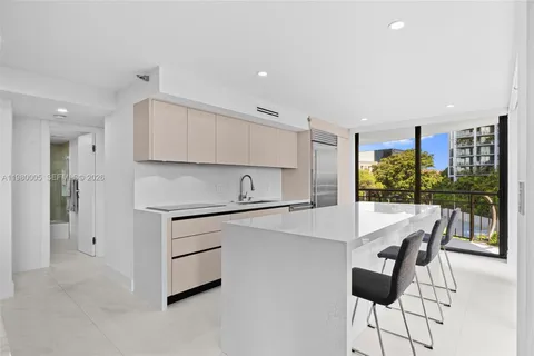 a kitchen with a table a refrigerator and cabinets