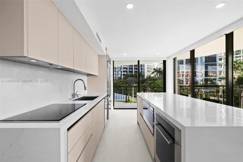 a large kitchen with stainless steel appliances a sink and cabinets