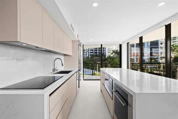 a large kitchen with stainless steel appliances a sink and cabinets