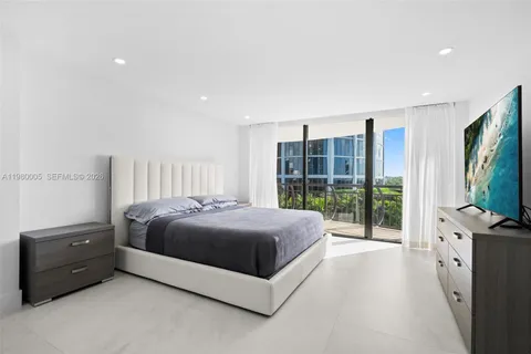 a spacious bedroom with a bed and glass door