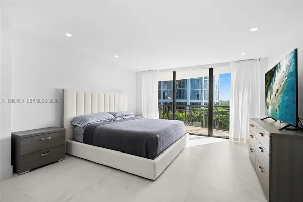 a spacious bedroom with a bed and glass door
