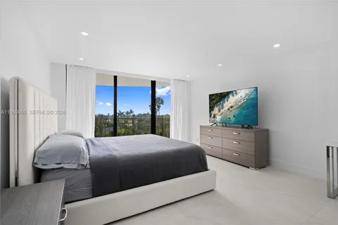 a bedroom with a bed and large windows