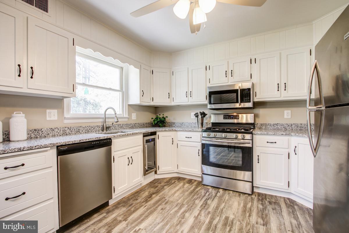 11803 Rocking Horse Road Rockville, MD 20852 - Photo 13 of 28 a kitchen with granite countertop white cabinets stainless steel appliances a sink and a window