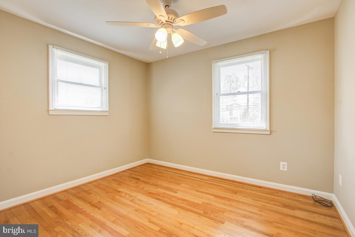 11803 Rocking Horse Road Rockville, MD 20852 - Photo 18 of 28 a view of empty room with wooden floor and fan