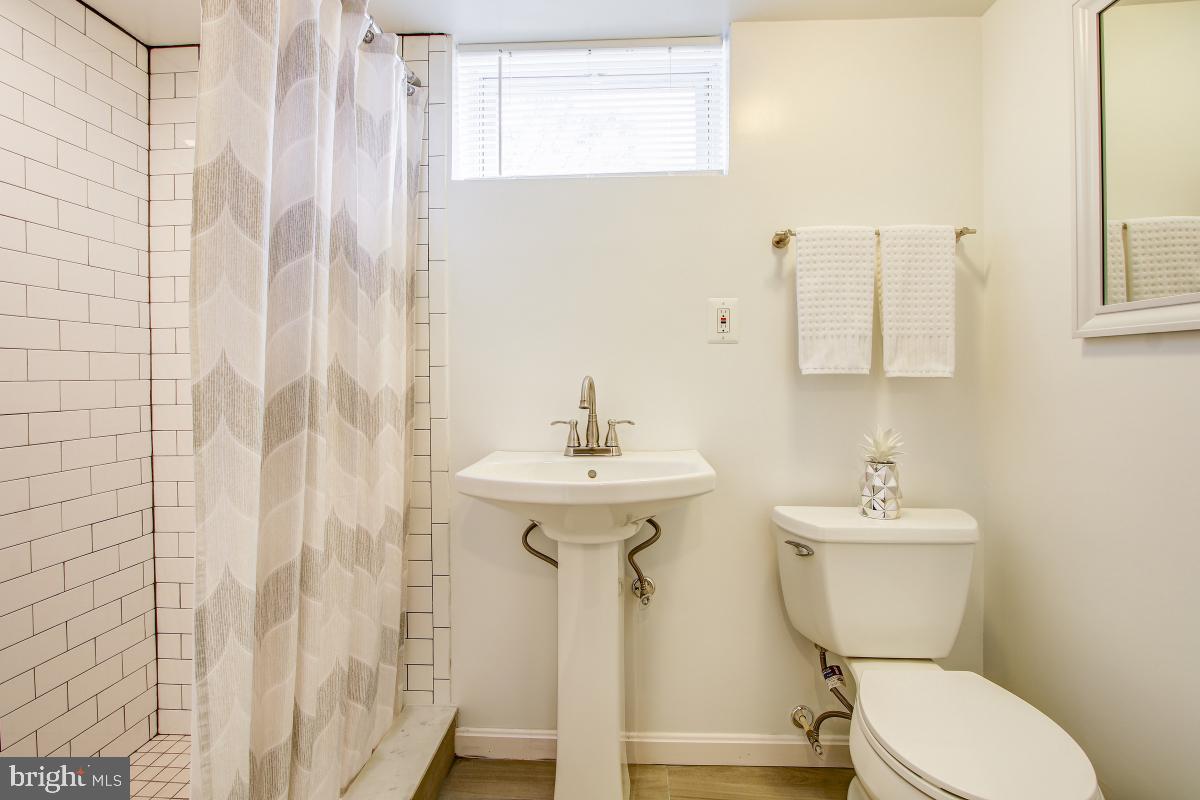 11803 Rocking Horse Road Rockville, MD 20852 - Photo 25 of 28 a bathroom with a sink mirror toilet and a shower