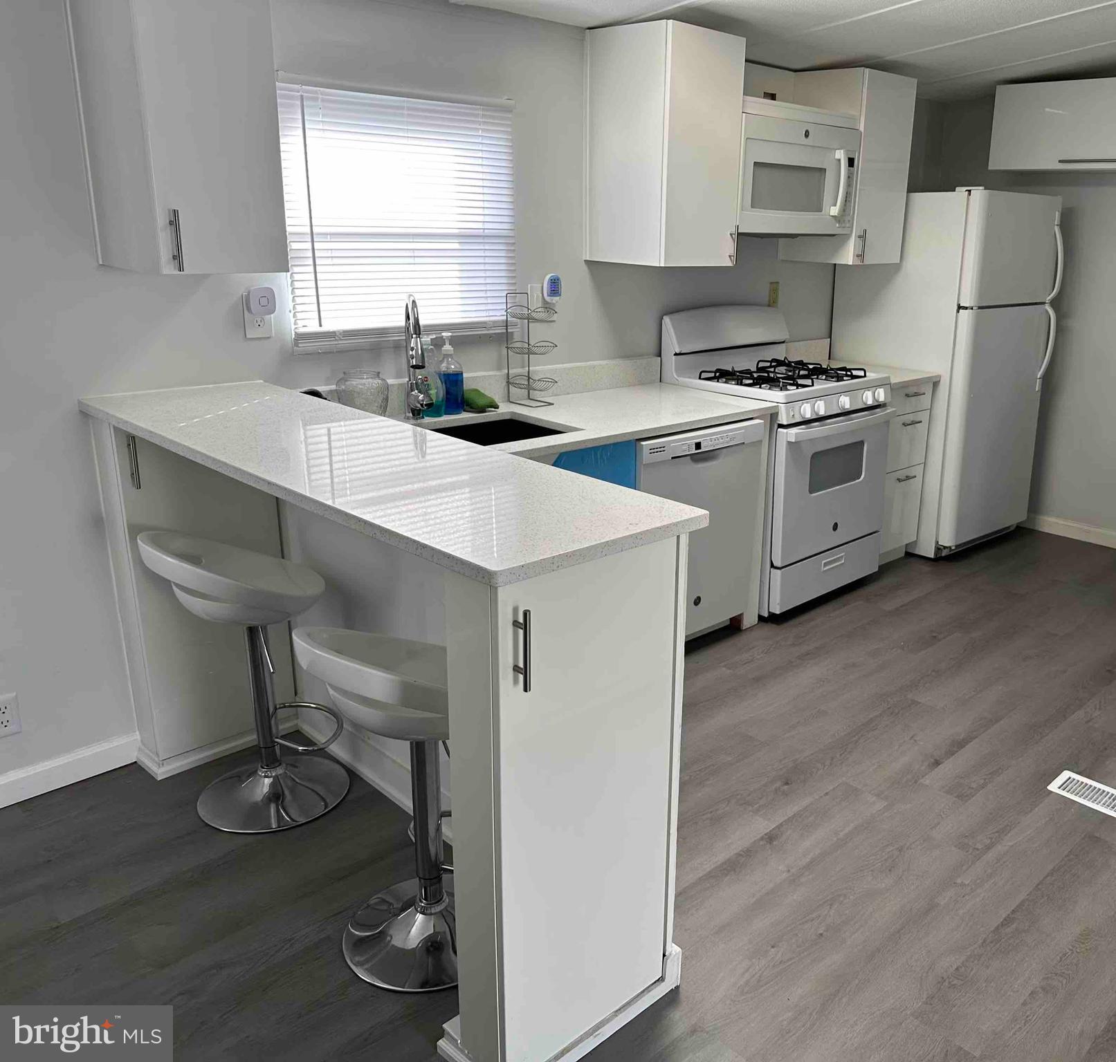 8353 Ashwood Road, Unit 8353 Jessup, MD 20794 - Photo 5 of 11 a kitchen with a sink cabinets and wooden floor