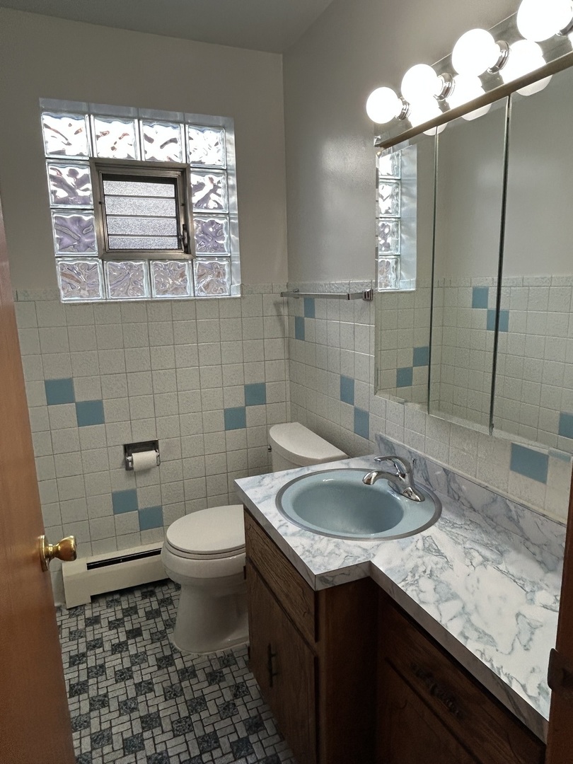 5350 North Central Avenue, Unit 1 Chicago, IL 60630 - Photo 13 of 24 a bathroom with a granite countertop sink a toilet and a mirror